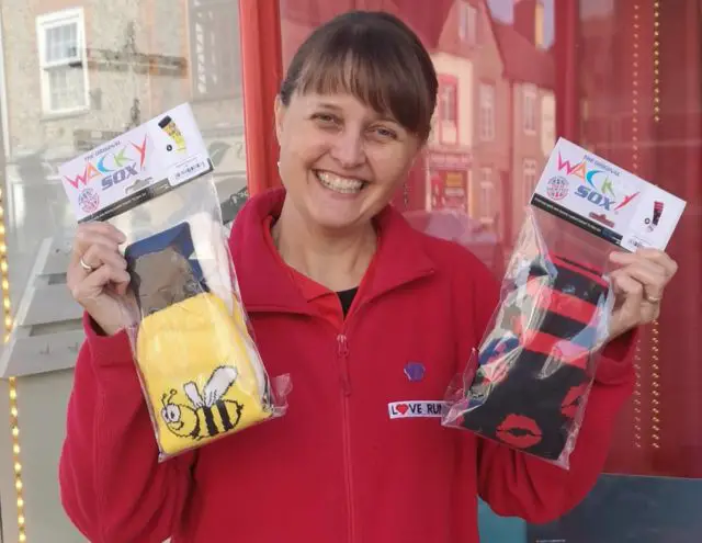 Jo from Love Running standing outside shop with with packets of wacky socks