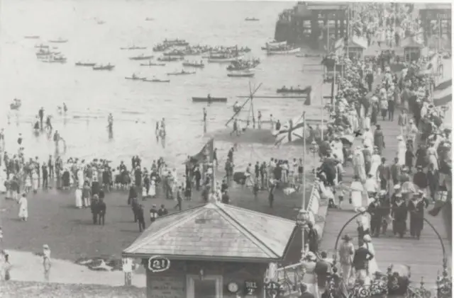 Sandown Regatta from 1905 with spectators on the pier on beach watching the rowers