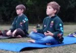Two scouts sitting on the ground cross legged