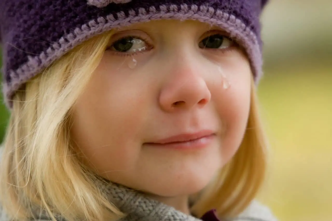 girl with woollen hat crying