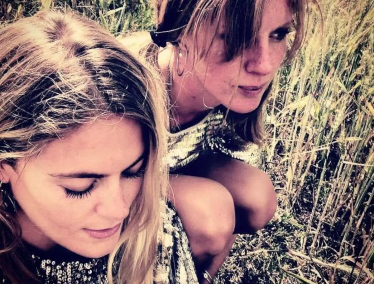 kat and hannah from Kat Fight band crouching in the grass