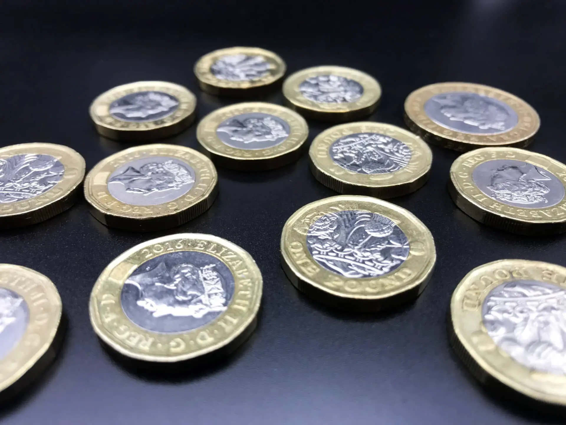 A number of new style one pound coins on table