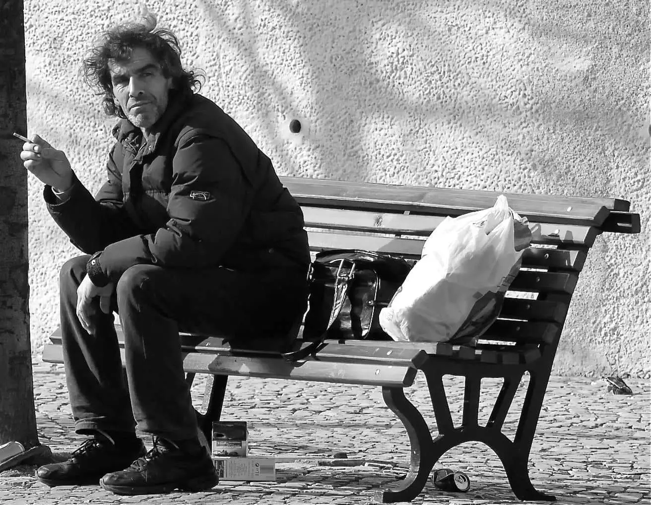 rough sleeper on a bench with a cigarette