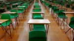 school desks set out in hall for examinations