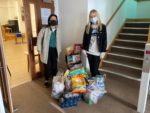 Two woman handing in food for Foodbank