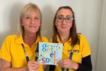 Two staff from Carers IW holding a get well soon card