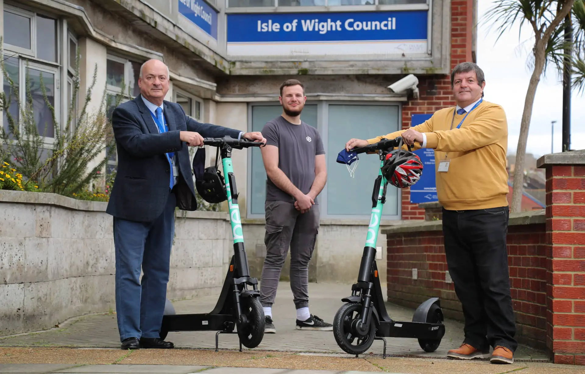 Ian Ward and Dave Stewart outside county hall with e-scooters