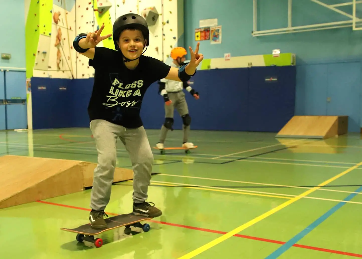john cattles skate club with lad on skateboard indicating Victory signs with both hands
