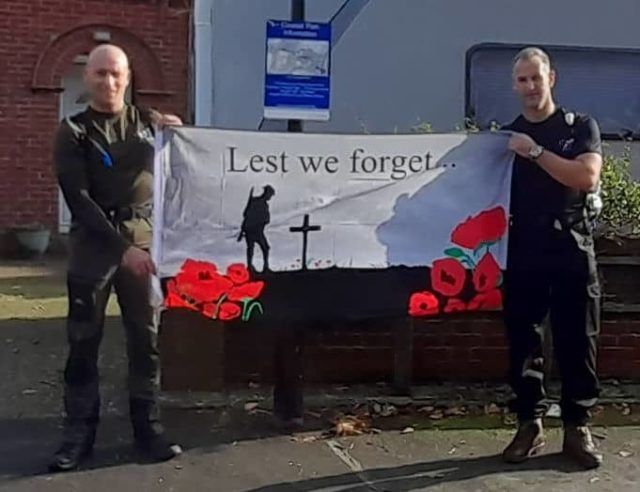 John Quayle and Grant Farley holding Lest We Forget flag