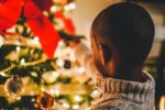 little boy looking at a decorated Christmas tree