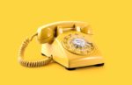 yellow dial telephone on yellow background