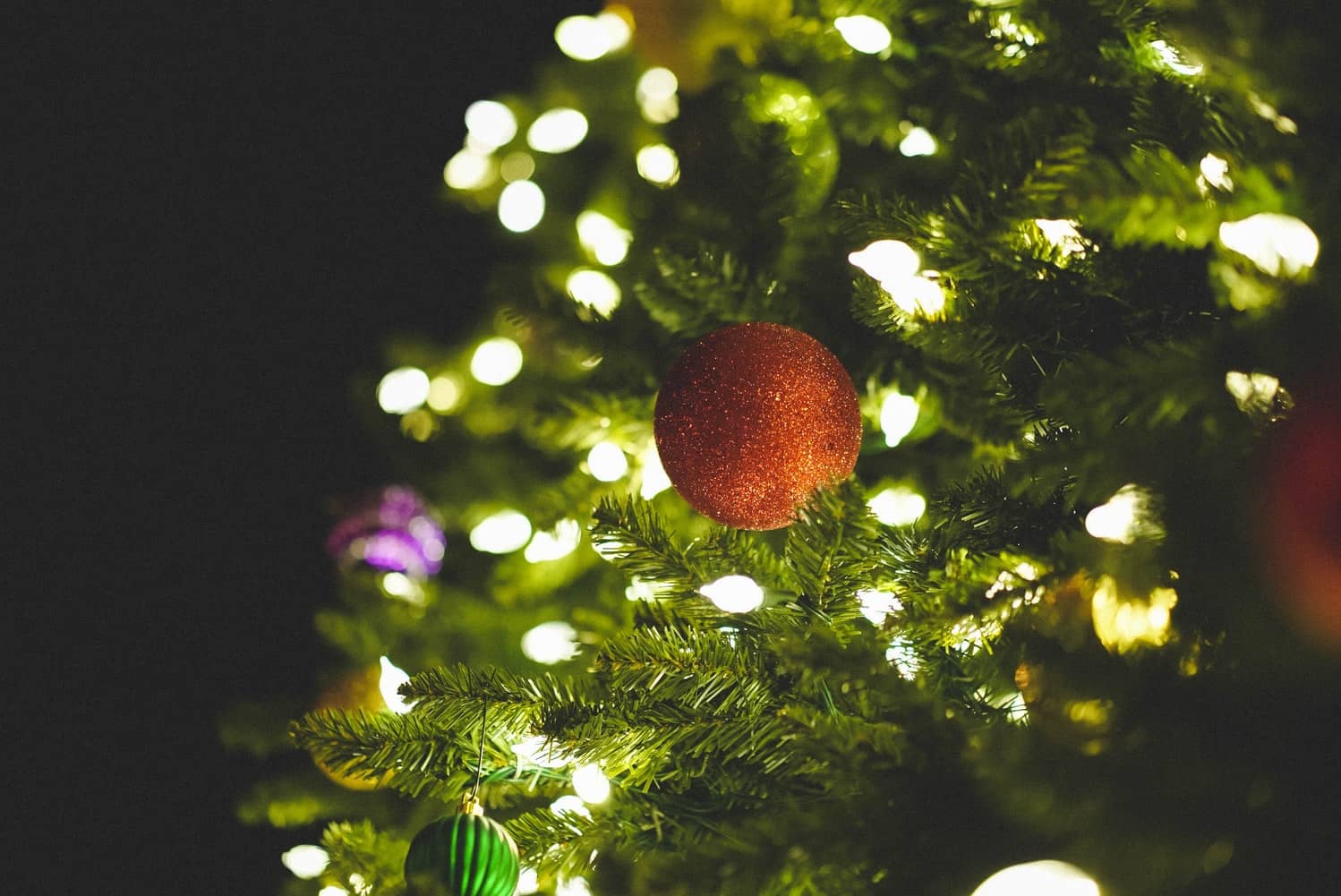 bauble on a christmas tree with fairy lights