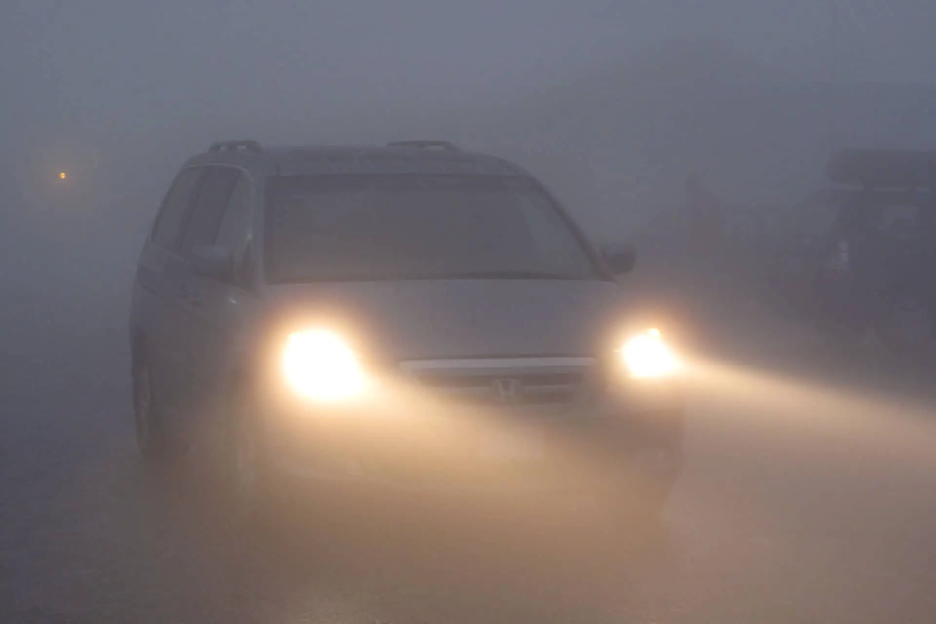 car with headlights driving in the fog