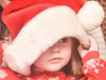 child with santa hat and xmas pyjamas on