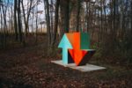 up and down arrow sculpture in the woods
