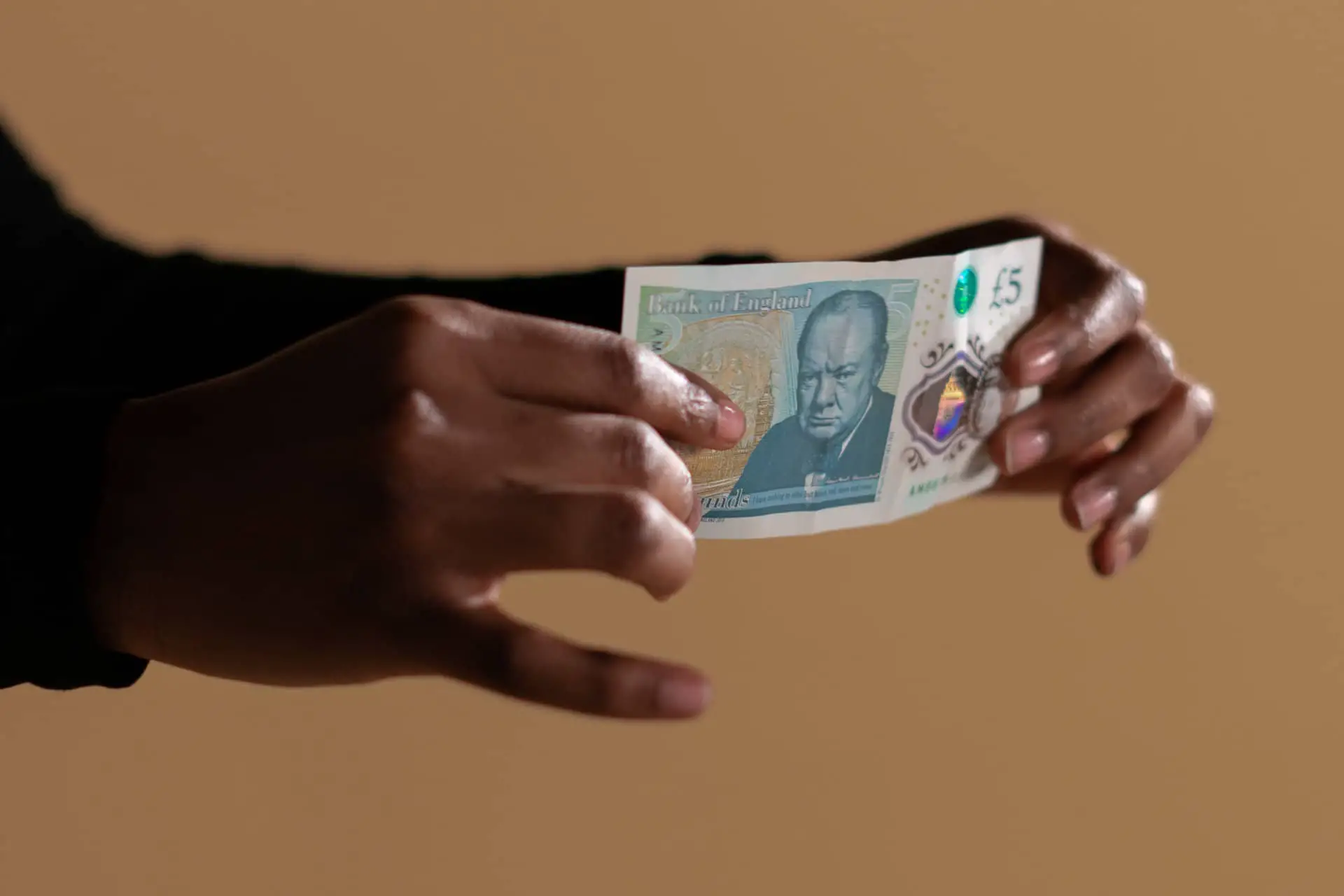 Person holding a five pound note