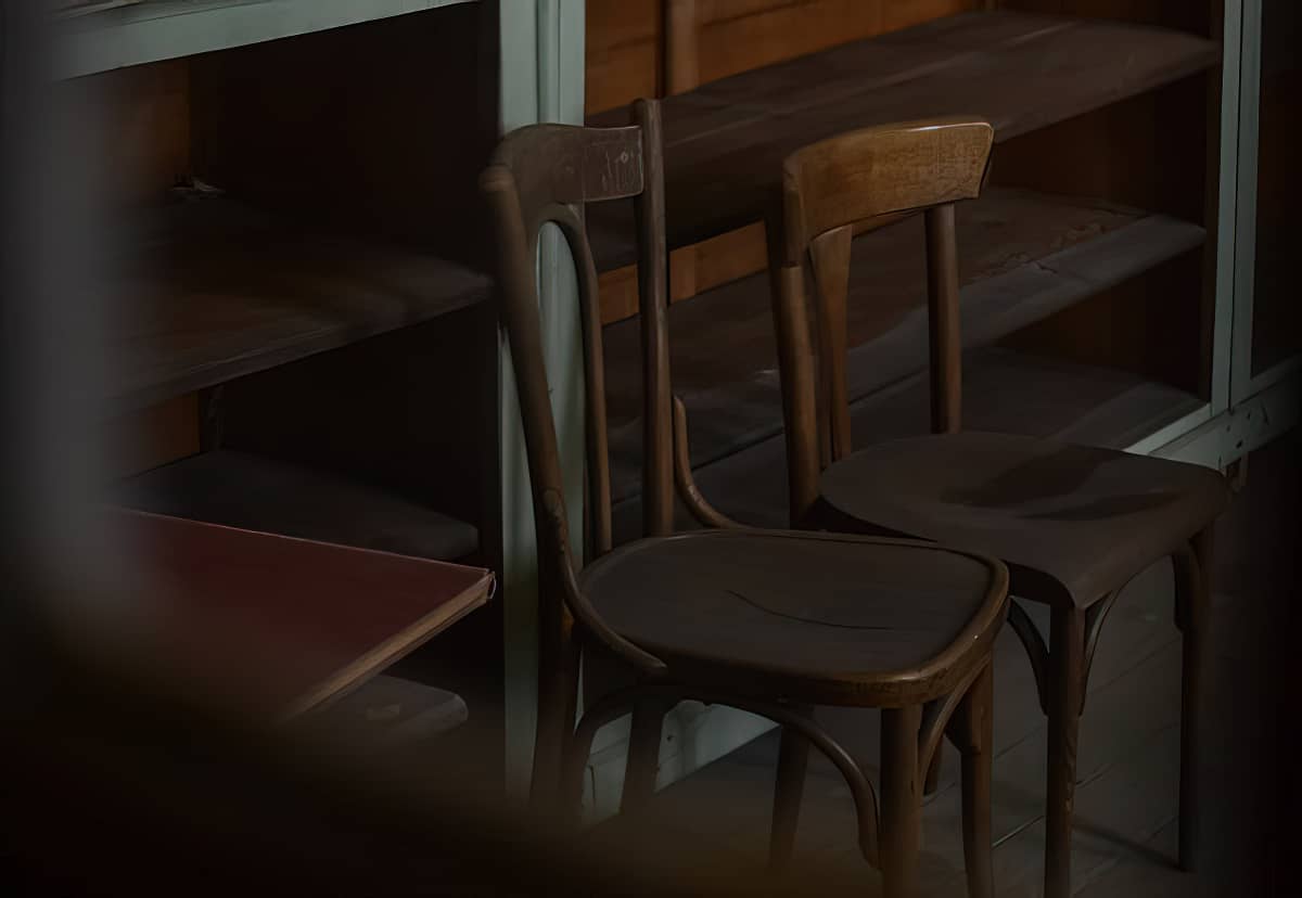 two wooden chairs in dark room