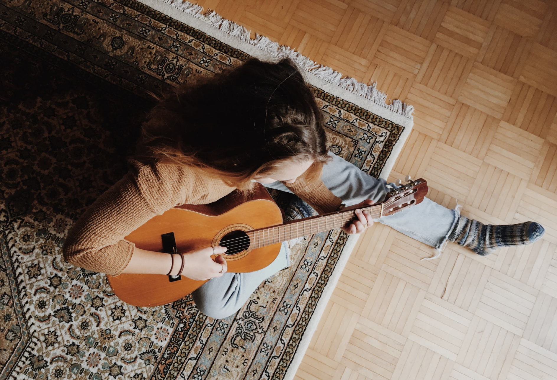 girl on floor playing guitar
