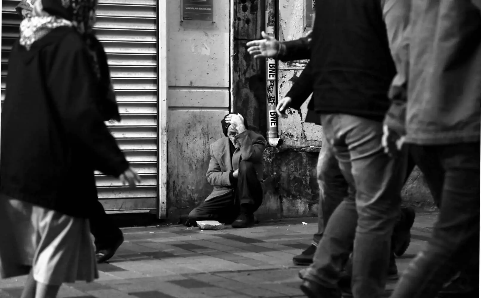 Homeless man sitting on the street asking for money