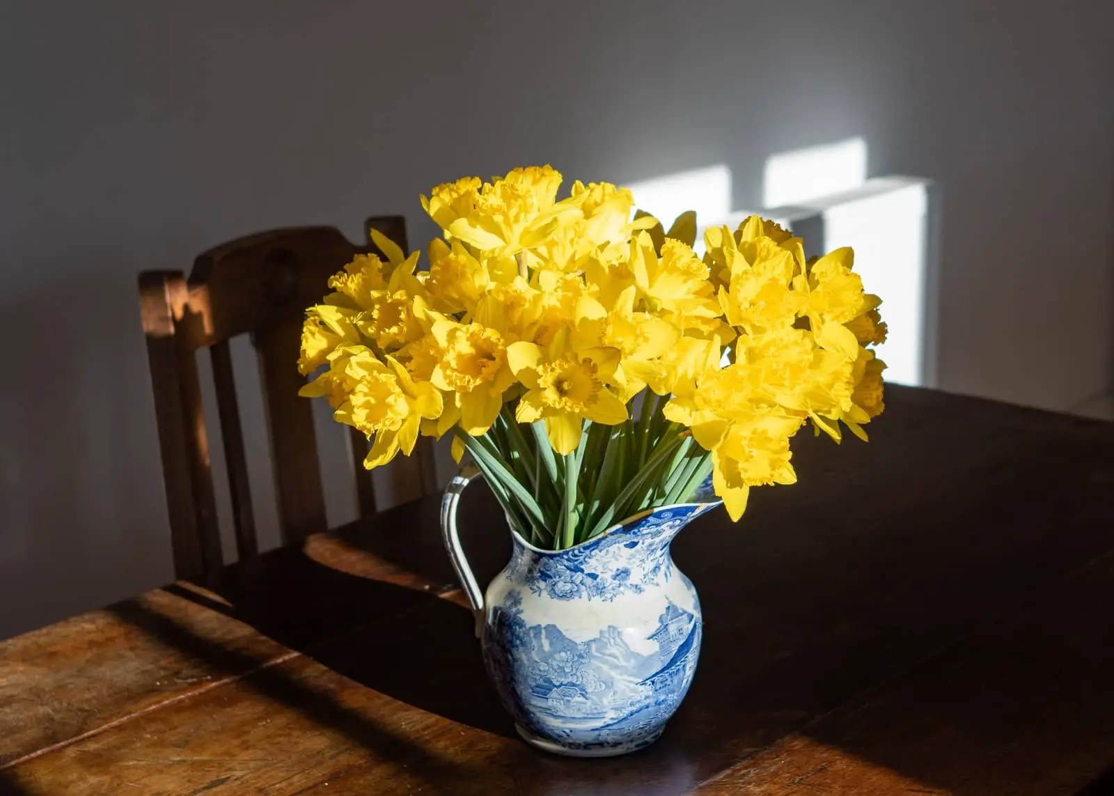 Vase with daffodils on a wooden table