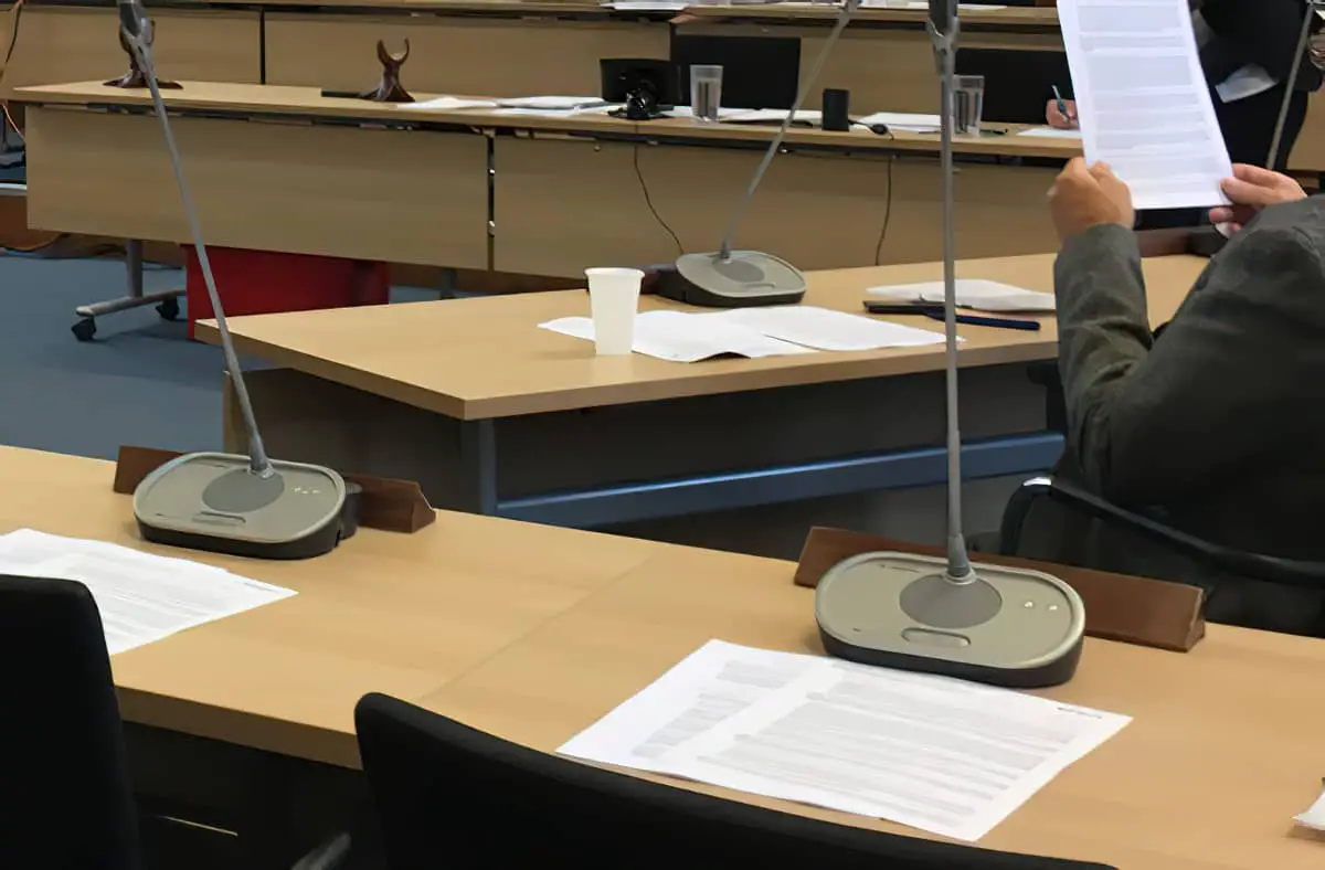 Council chamber, papers on desks with pa microphones