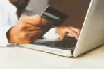 person on laptop holding credit card by rupixen
