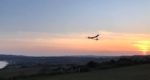 Bottle plane flying over Culver with sunset in background