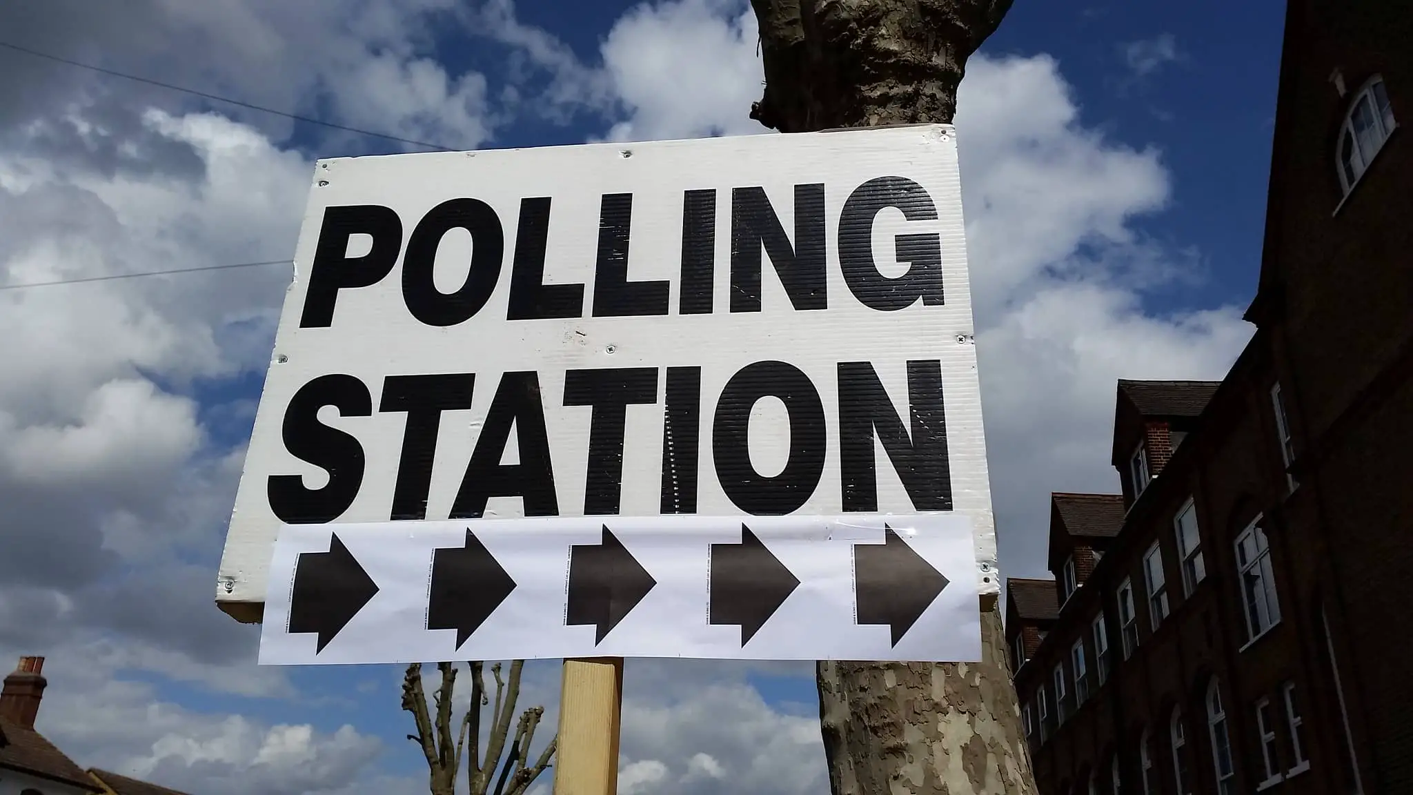 Polling station sign with blue sky in background