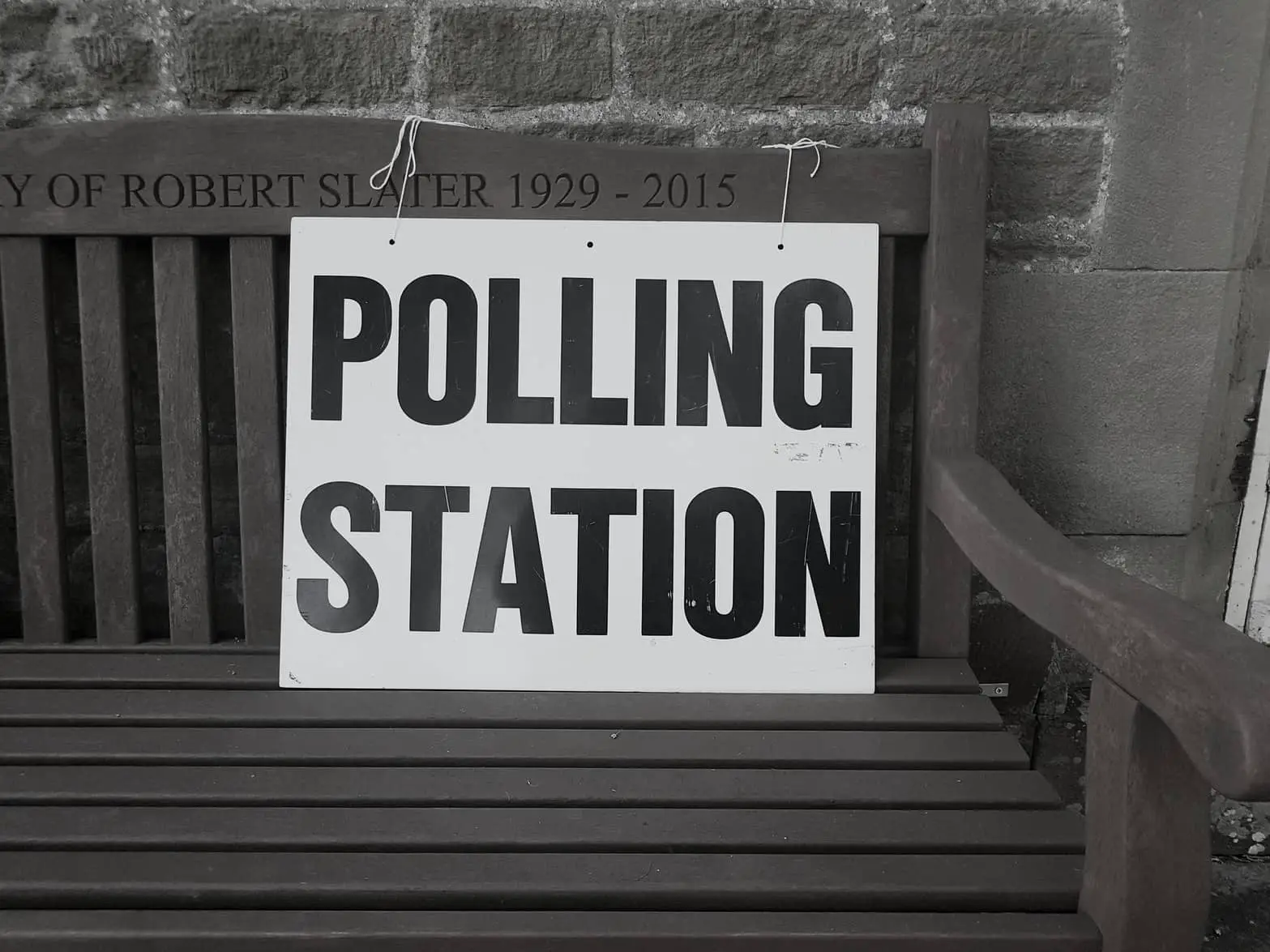 Polling station sign on a bench