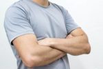 man wearing grey t-shirt with arms crossed