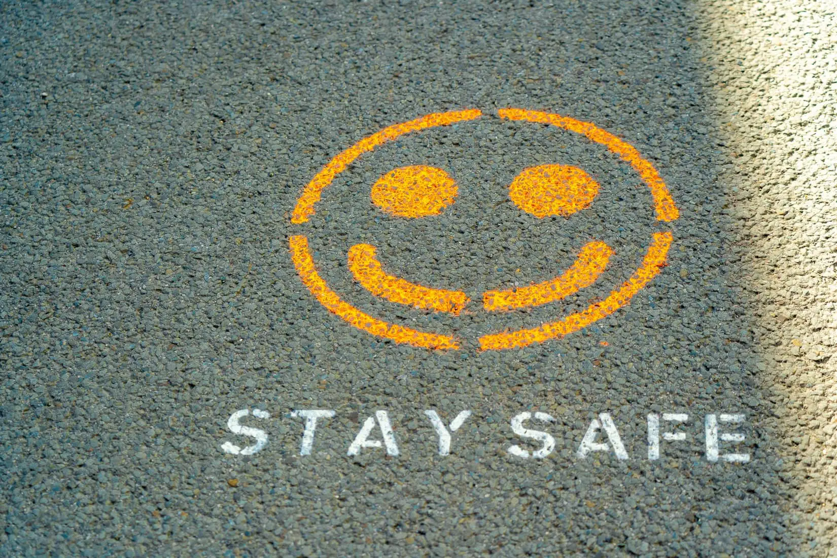 stay safe message on road with a smiley face by Nick Fewings