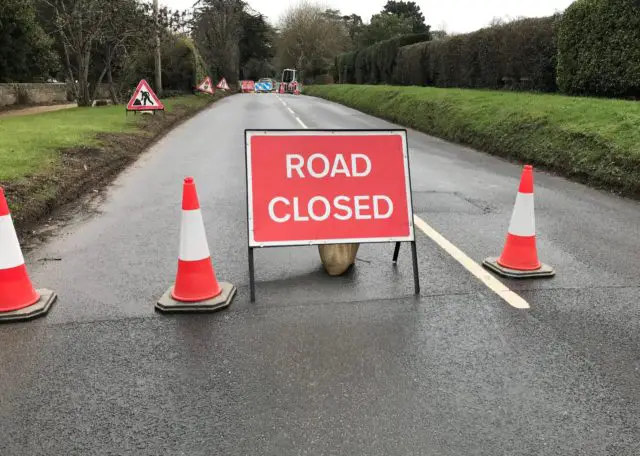 Road closed sign blocking access to road