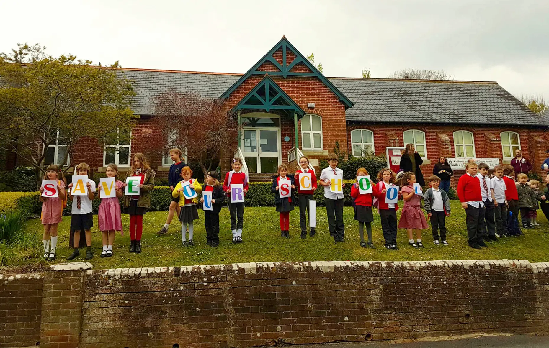 pupils outside school with save our school banner