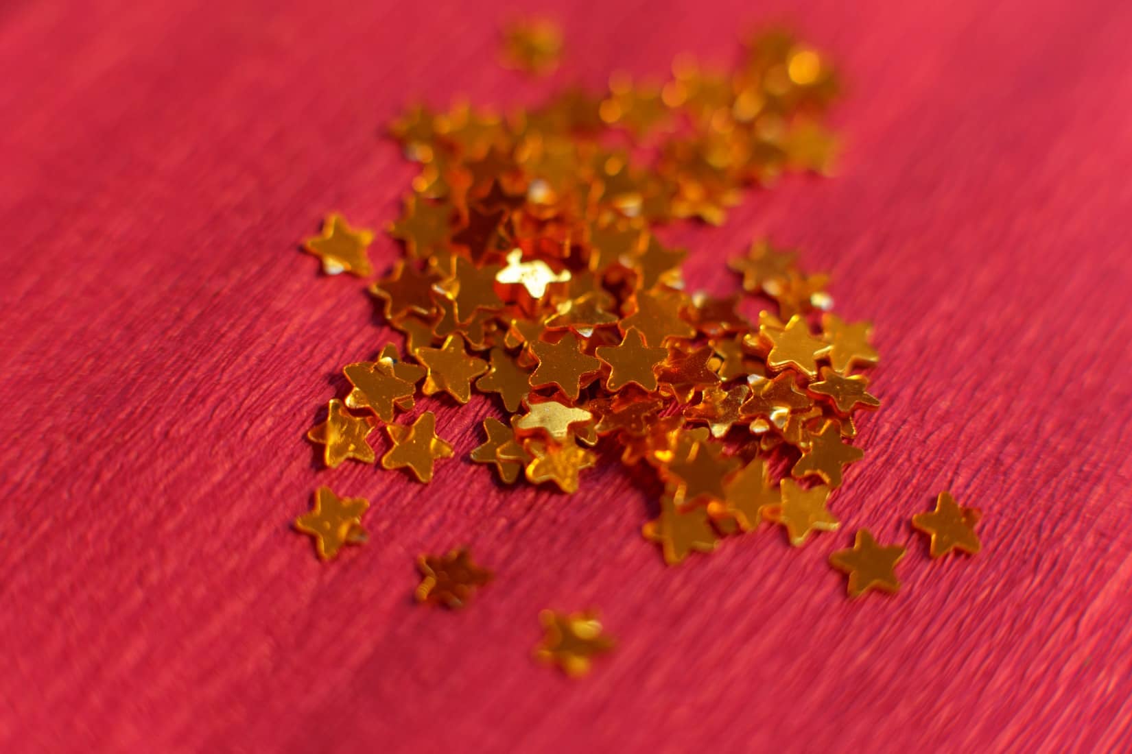 Pile of gold stars on red surface
