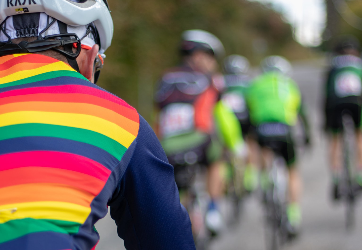 Cyclist with rainbow vest on by Greg Rosenke