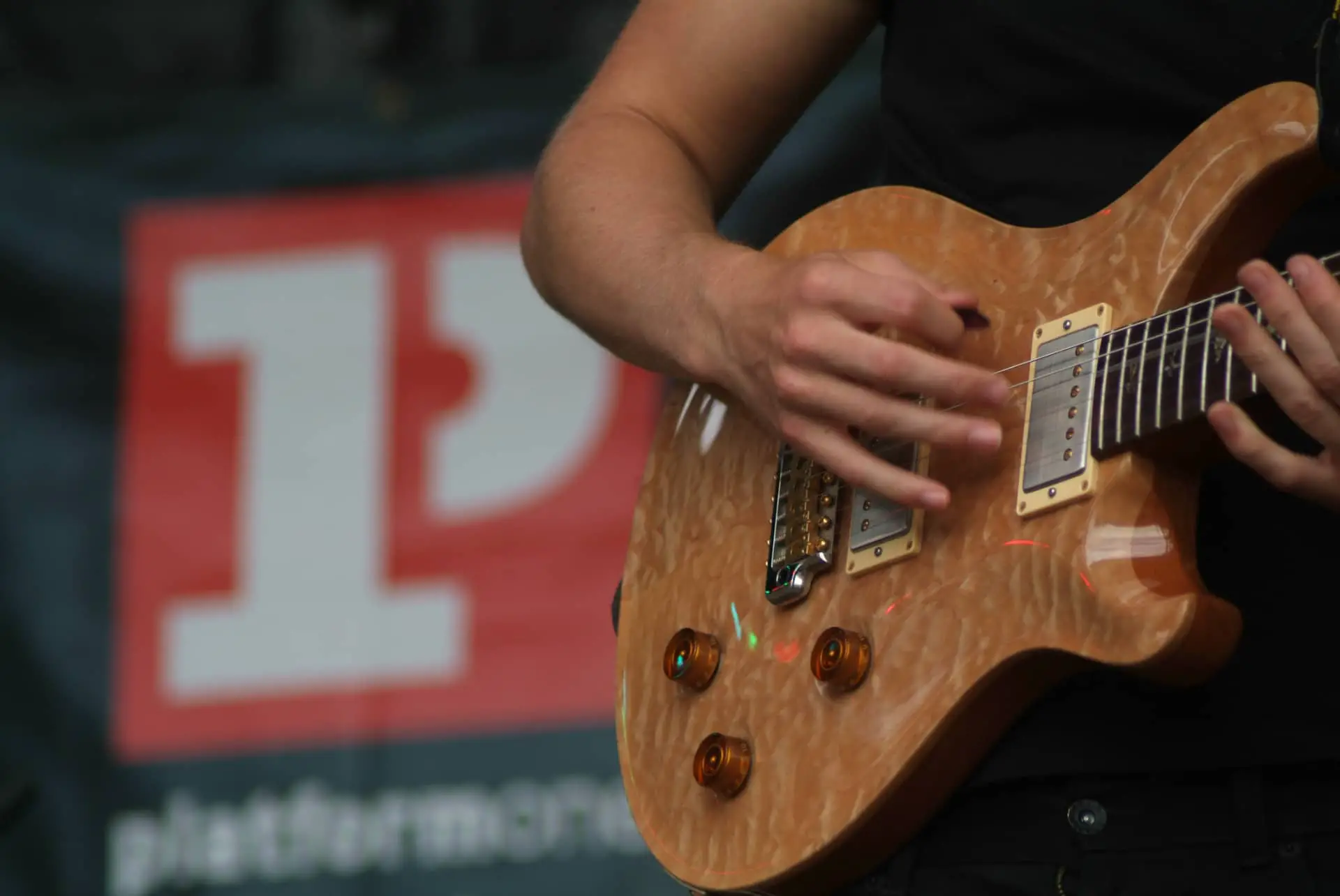 Close up of person playing guitar on stage