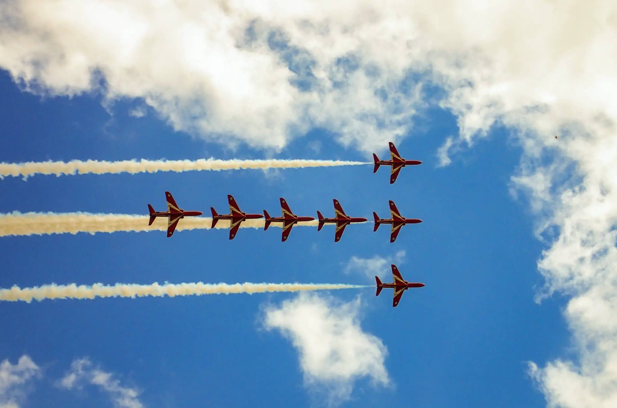 Red Arrows against a blue sky and fluffy clouds by Steven Penton