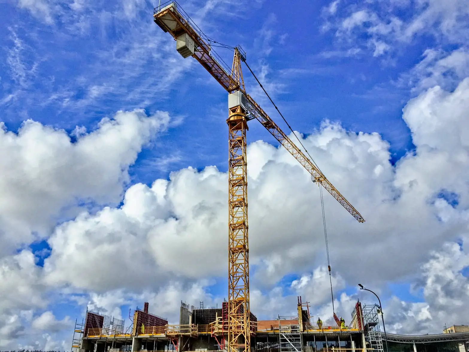 crane above building site with blue sky in background