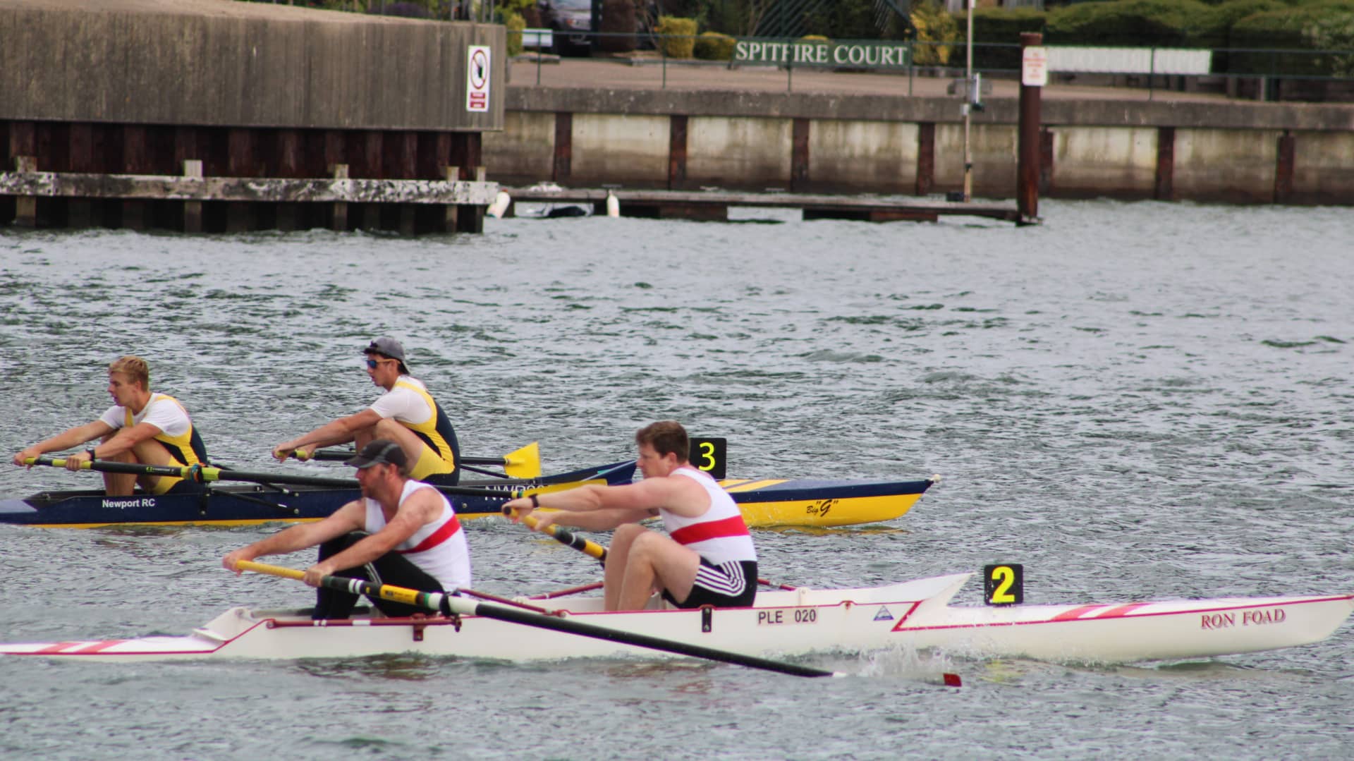 Newport crew on the far side off the start in the in gold and navy strip