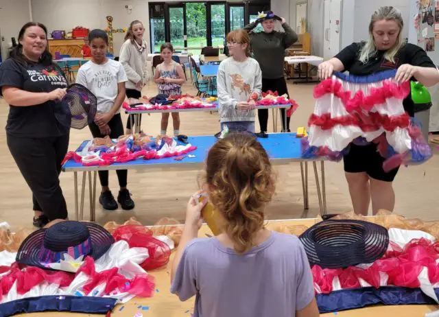 NCC artist Sharon Poole with children making their Carnival Queens outfits