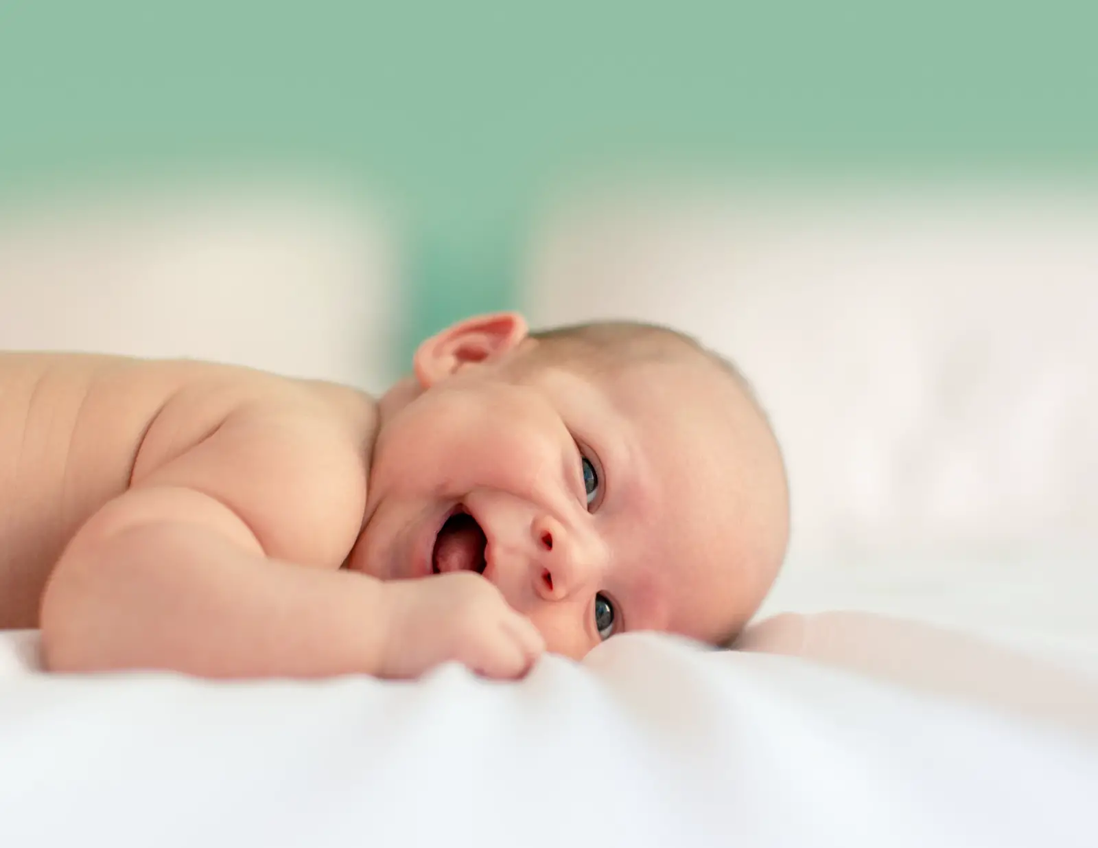 Smiling baby lying on a white towel