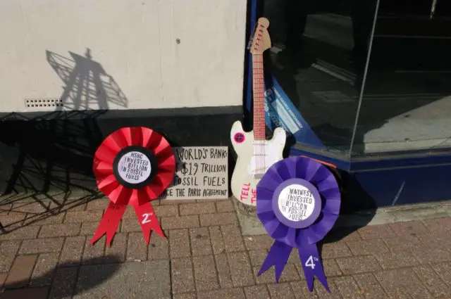 The carboard Fender Stratocaster and rosettes for banks investing in fossil fuels