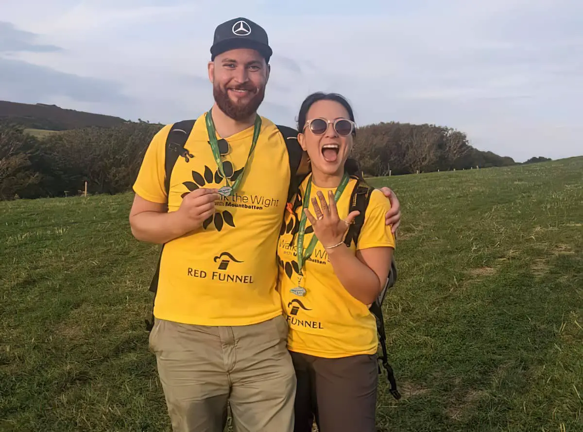 Will and Jojo at the end of walk the wight showing medals and engagement ring