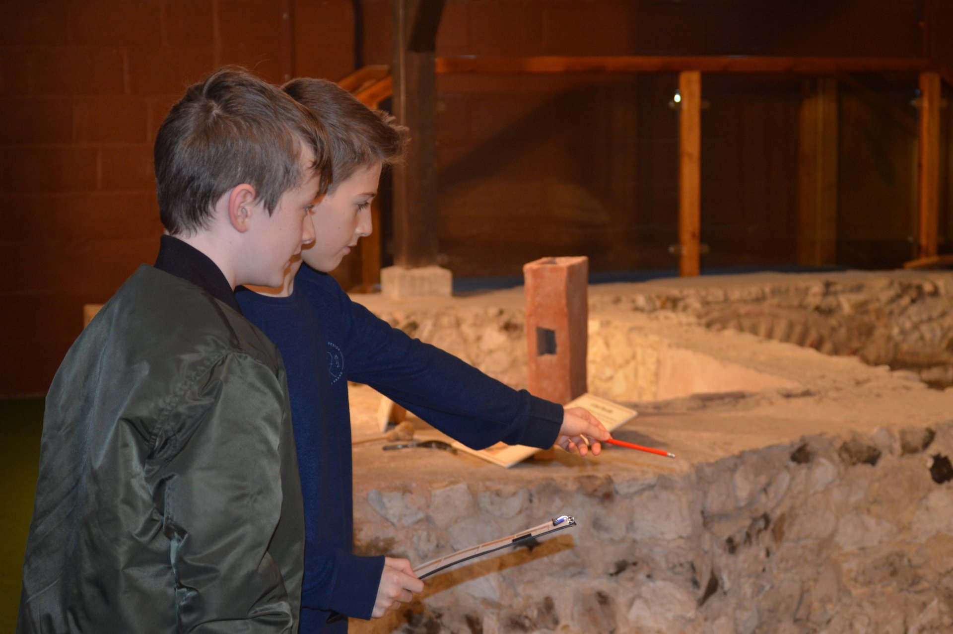 Two boys looking at Roman villa remains