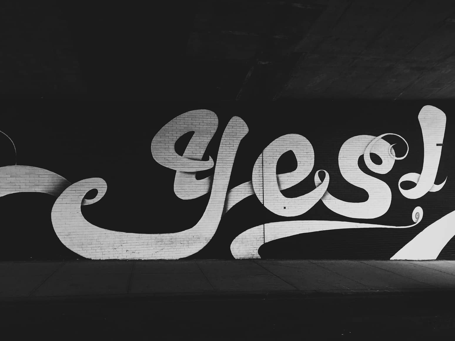 Graffiti on large wall spelling out 'yes'