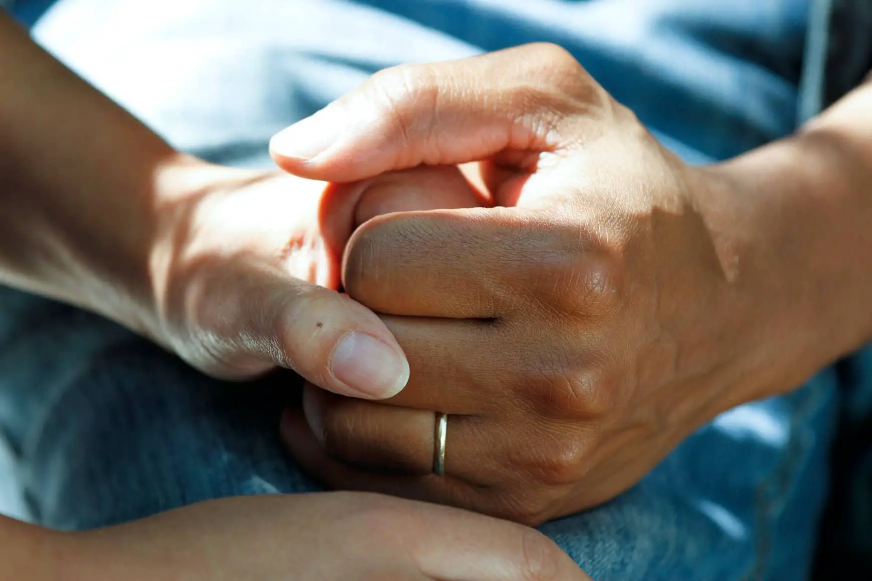 carer or nurse holding the hand of another person