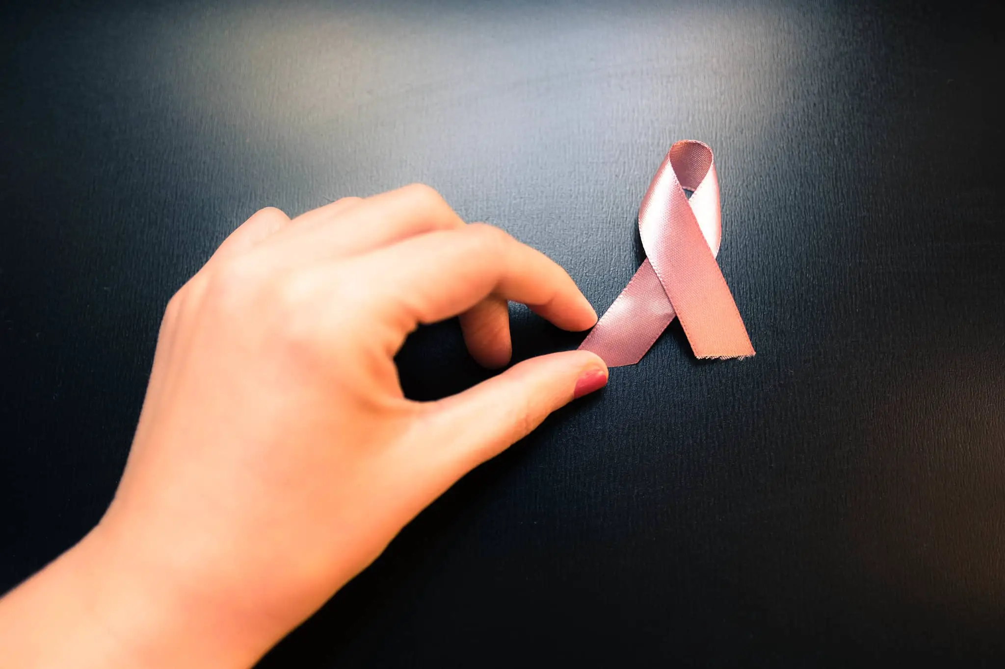 woman's hand and breast cancer awareness ribbon