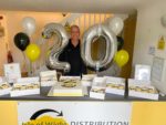 Chris from IW Distribution with balloons and cakes
