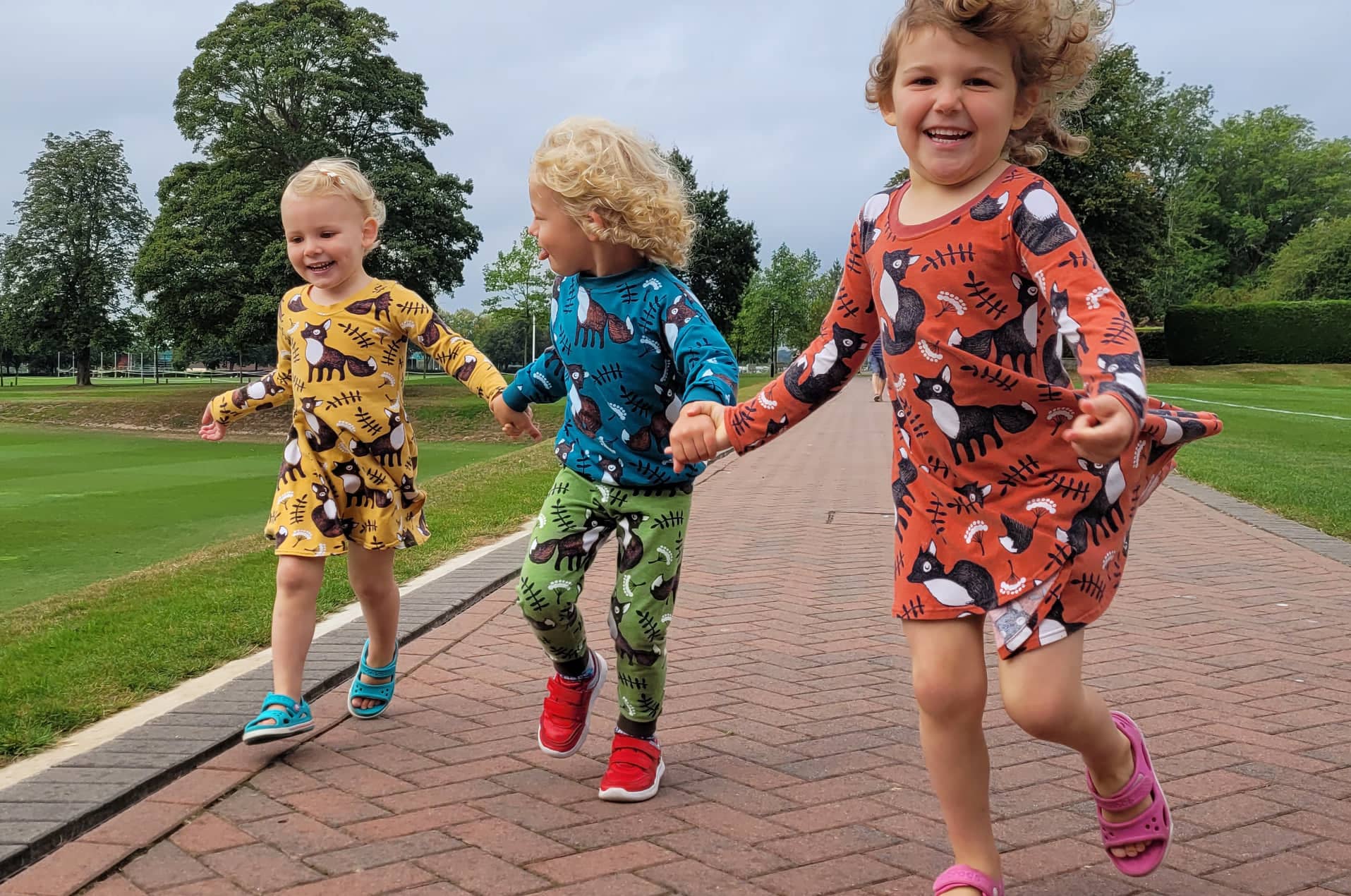 Zoe and Zack clothing on three young children running in a park