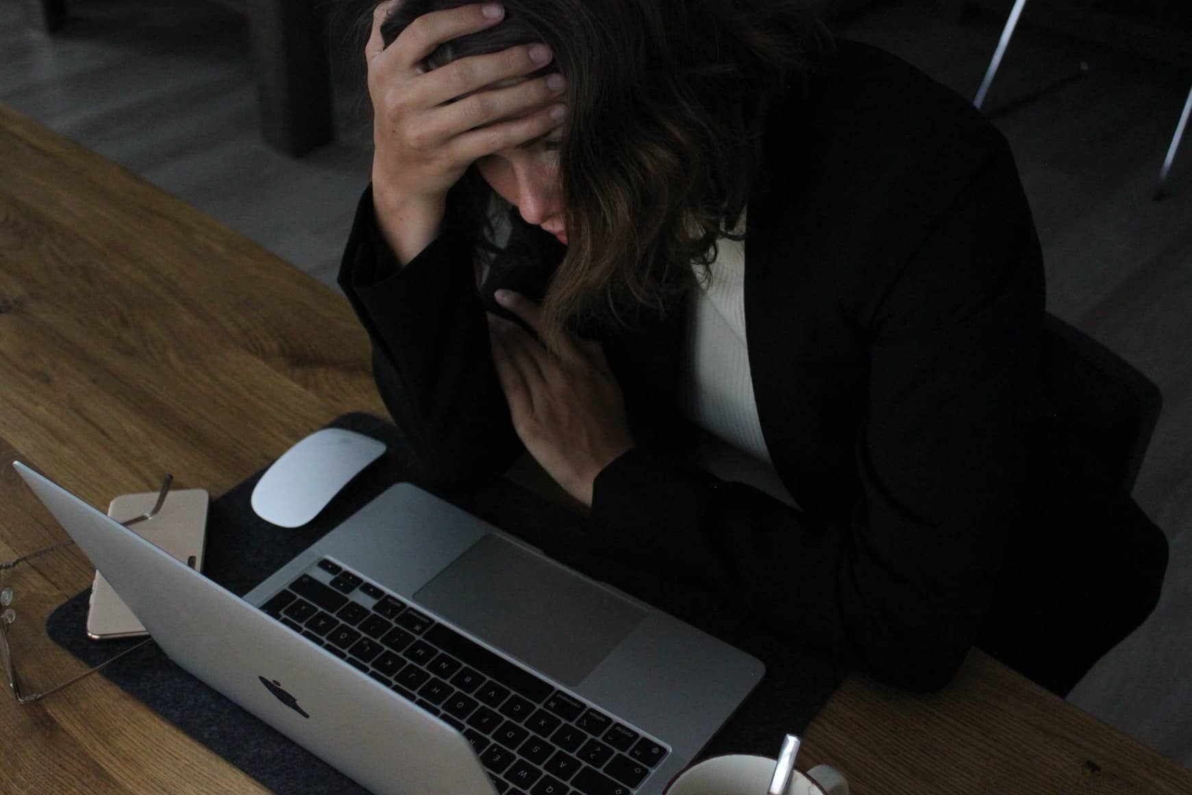 woman sat at laptop looking stressed